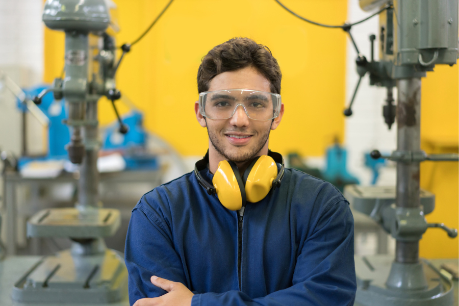 Portrait of an engineering student wearing protective wear and smiling - education concepts