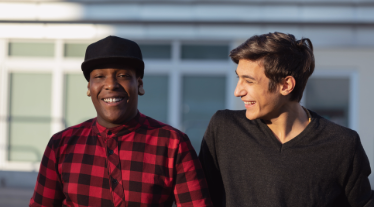 Two teenagers laughing outside. 